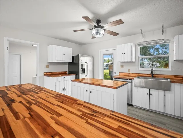 a kitchen with granite countertop a sink cabinets stainless steel appliances and a window