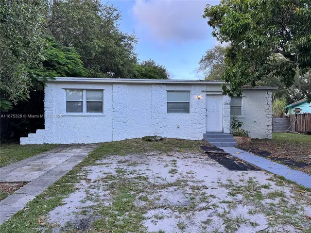 a backyard of a house with plants and trees
