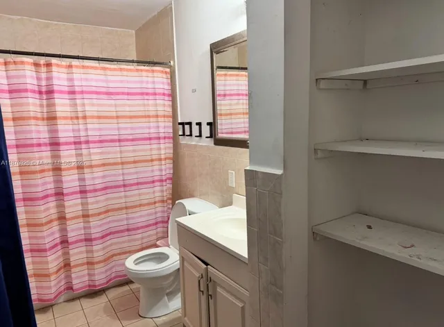 a view of a hallway with closet and a bathroom