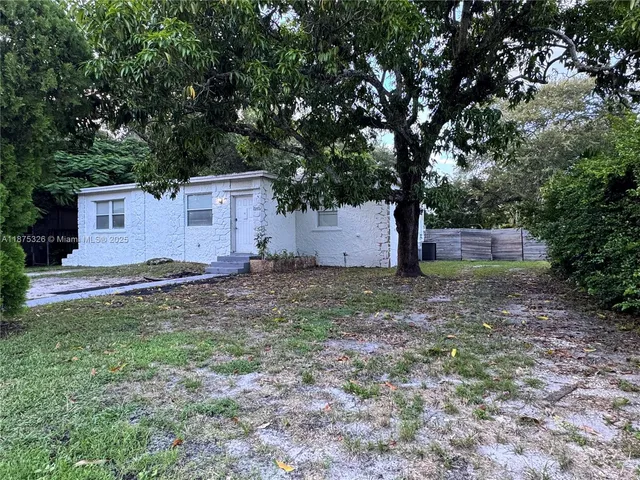 a backyard of a house with a tree