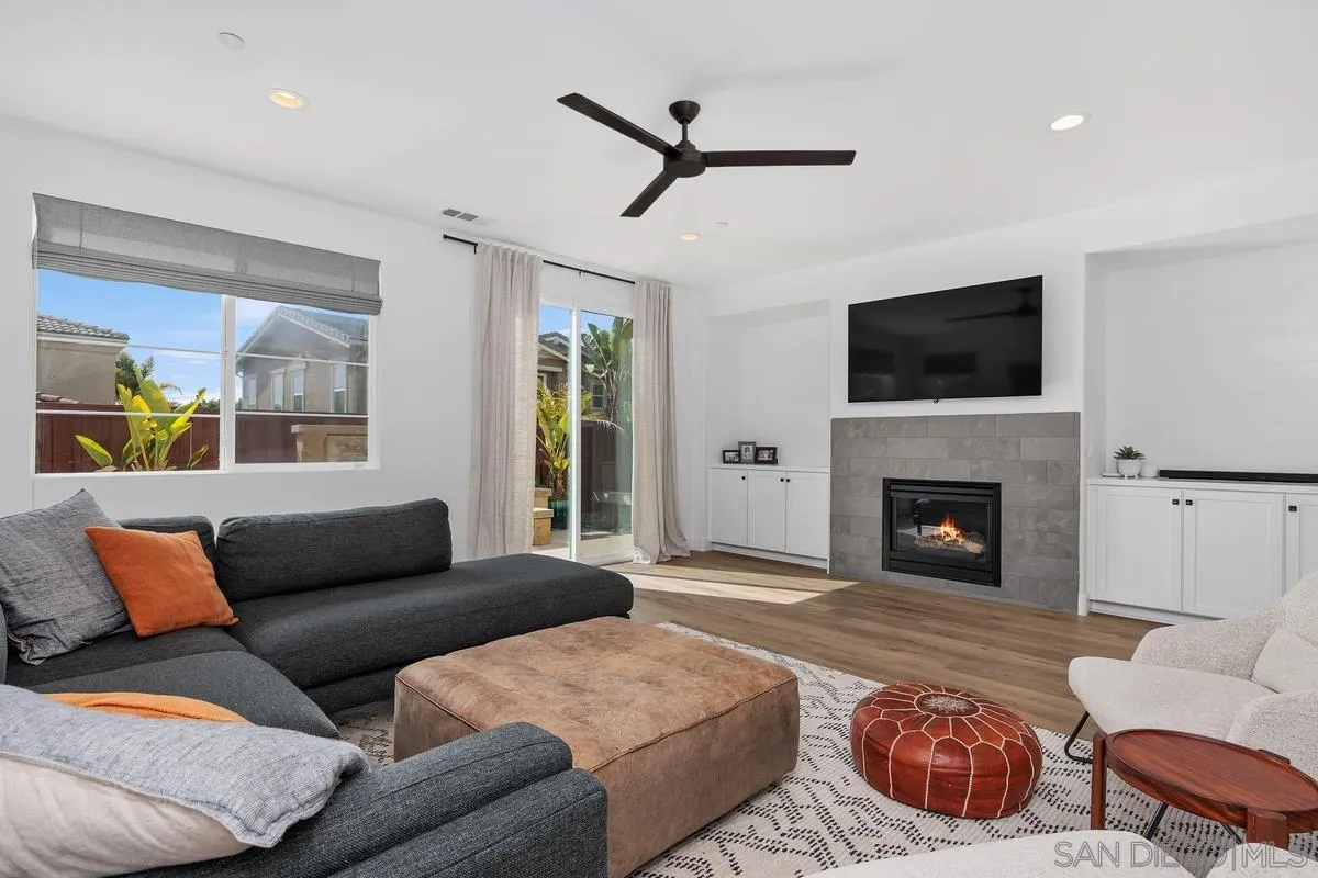 3741 Bergen Peak Place Carlsbad, CA 92010 - Photo 5 of 39 a living room with furniture a fireplace and a flat screen tv