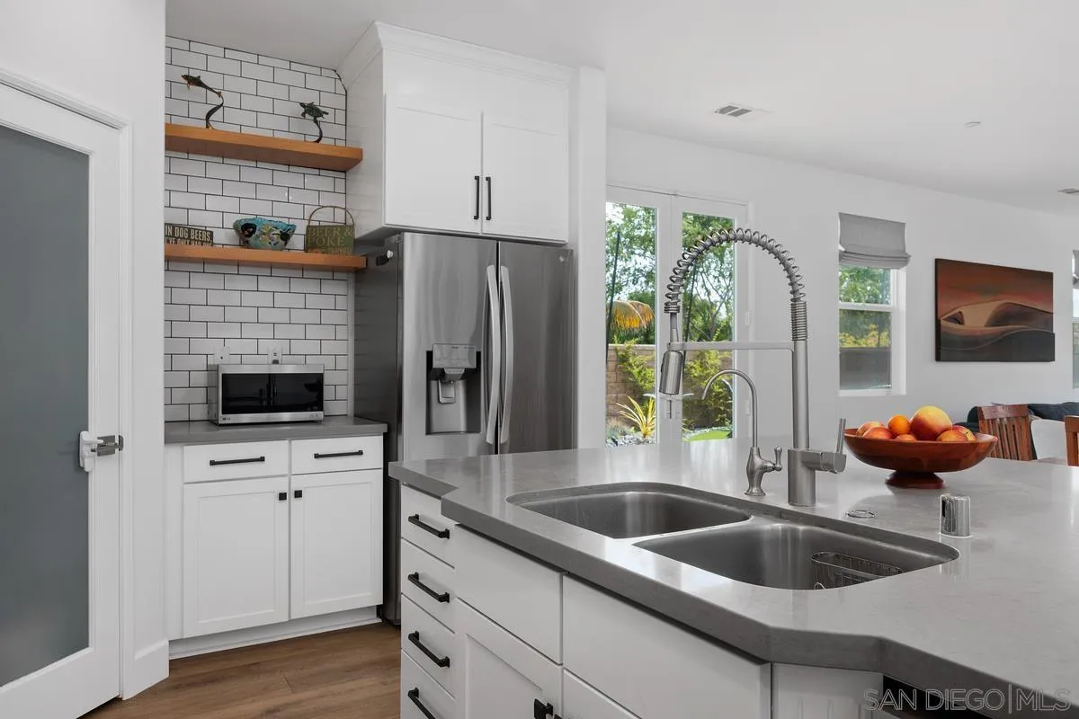 3741 Bergen Peak Place Carlsbad, CA 92010 - Photo 10 of 39 a kitchen with stainless steel appliances a sink a refrigerator and a window
