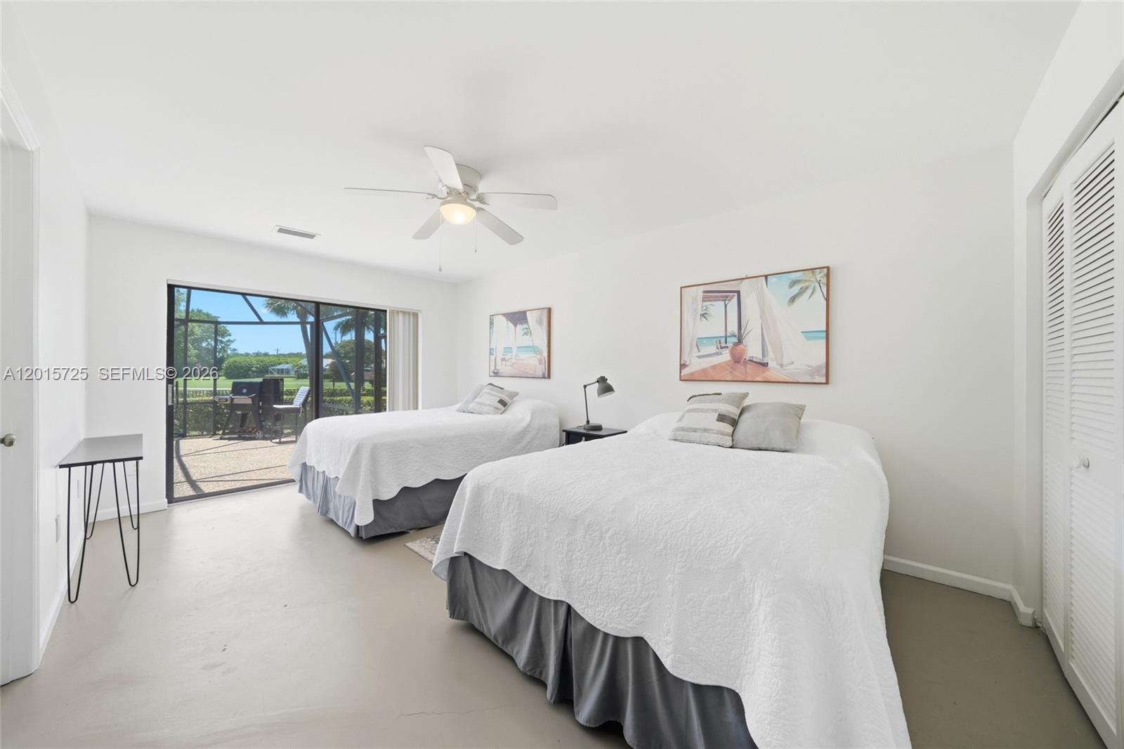 11008 Boca Woods Lane Boca Raton, FL 33428 - Photo 25 of 70 a bedroom with two beds and a chandelier
