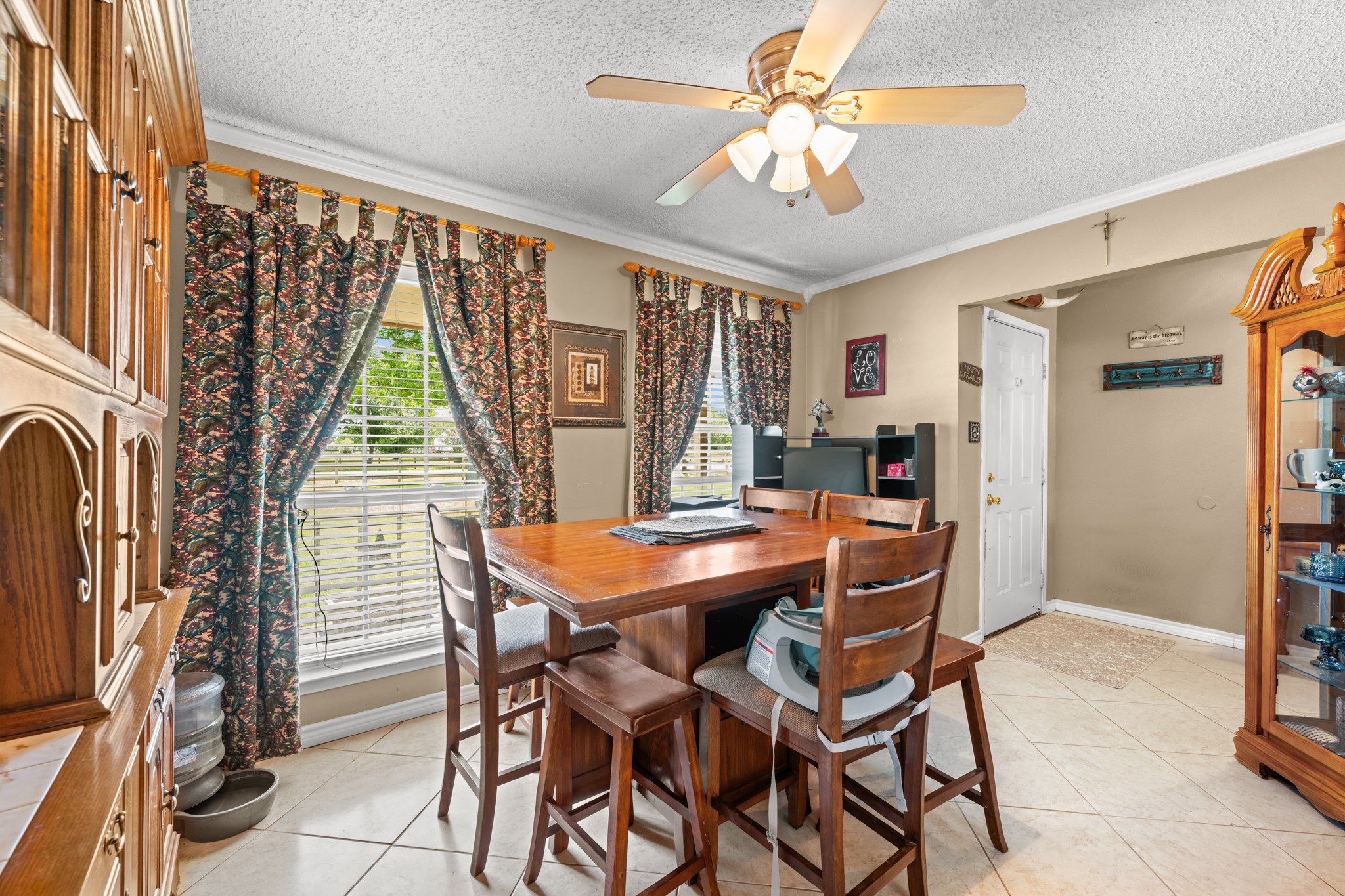 15602 Fir Road Santa Fe, TX 77517 - Photo 6 of 42 Bright and inviting dining space highlighted by oversized windows, crown molding, and abundant natural light. The open layout offers a comfortable setting for casual meals, entertaining, or gathering with family and friends.