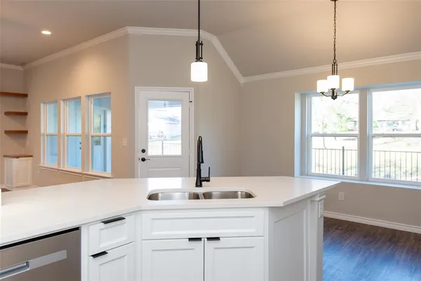 a kitchen with a sink and chandelier