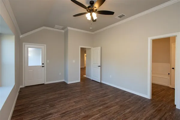 a view of an empty room with window a ceiling fan and wooden floor