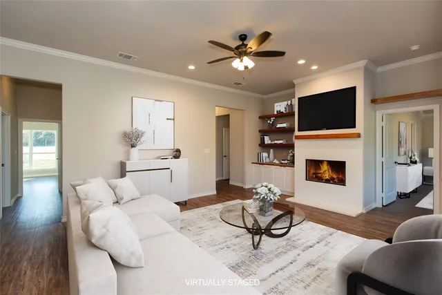 a living room with furniture a flat screen tv and a fireplace