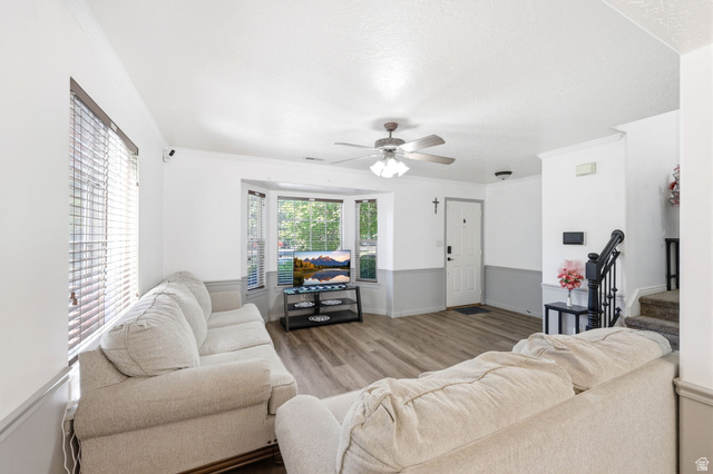 984 Independence Avenue Provo, UT 84604 - Photo 2 of 19 Spacious living area featuring wood-finish flooring, a bay window, and a ceiling fan with integrated lighting
