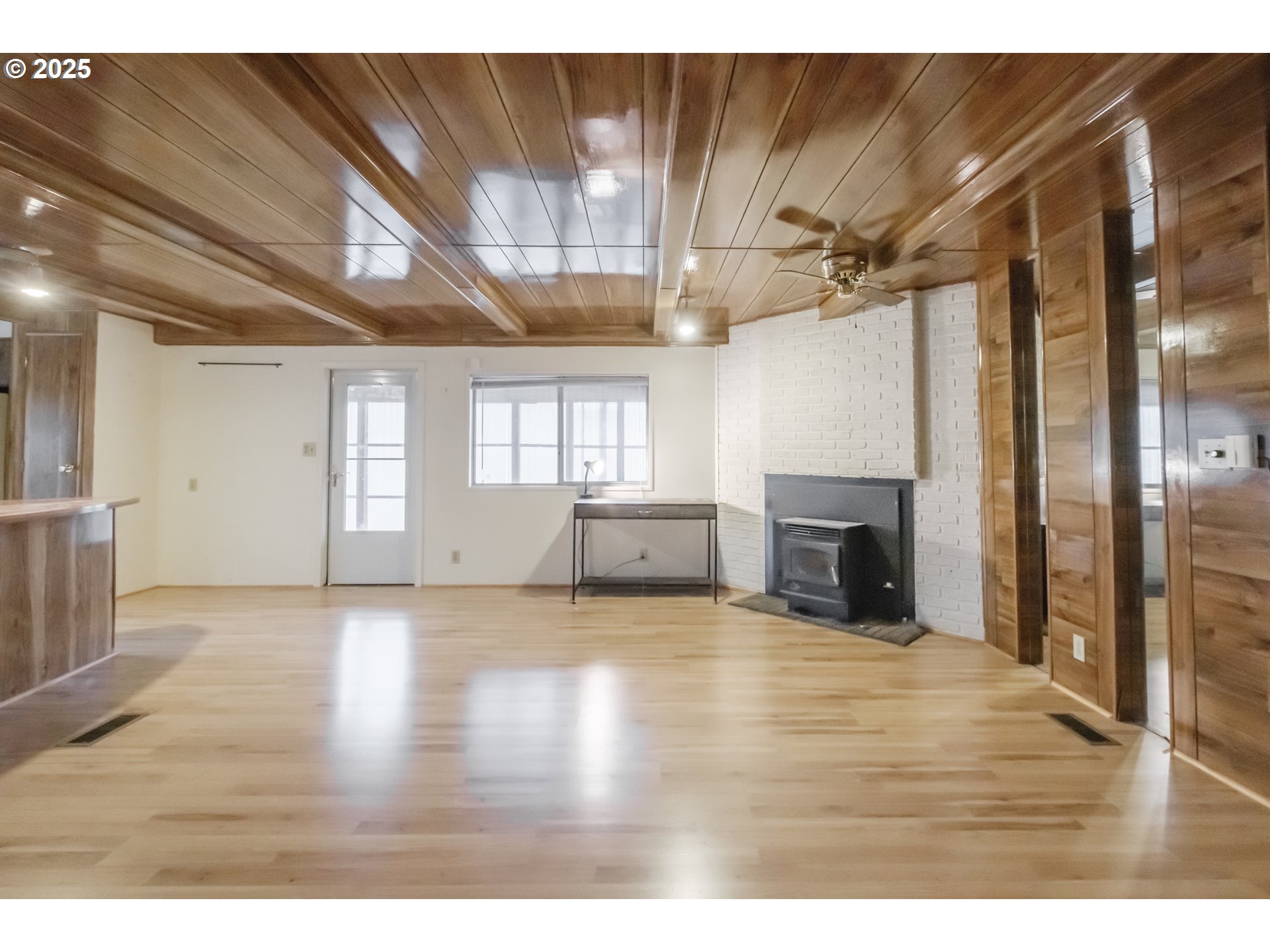 3760 Highway 101, Unit 7A Florence, OR 97439 - Photo 6 of 34 a view of an empty room with wooden floor and a kitchen