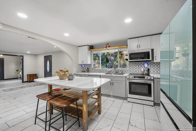 a kitchen with stainless steel appliances kitchen island granite countertop a sink and cabinets