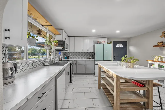 a kitchen with a sink a counter top space stainless steel appliances and cabinets