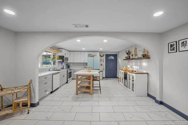a kitchen with a sink and chairs