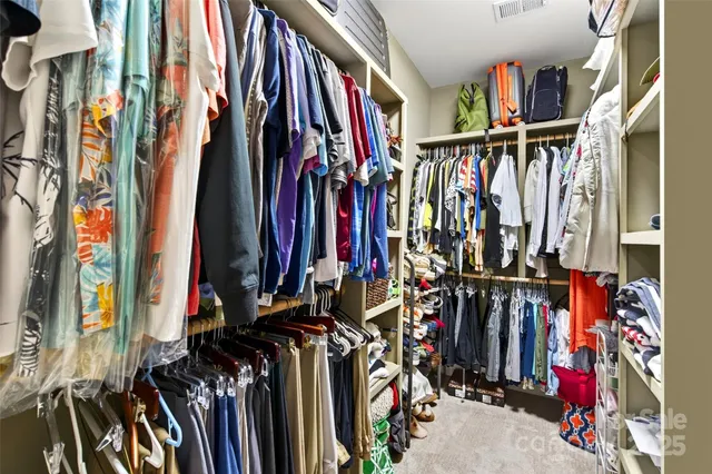 a view of walk in closet with clothes