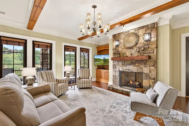 a living room with furniture a fireplace and a chandelier
