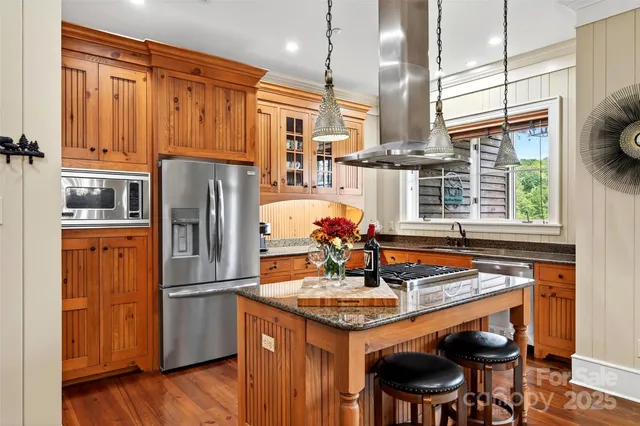 a kitchen with stainless steel appliances granite countertop a refrigerator a sink and a stove