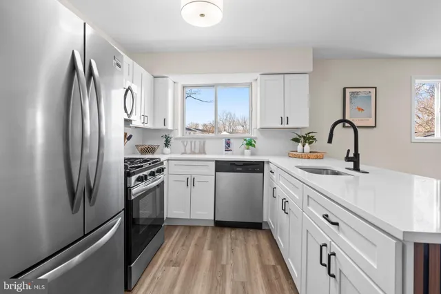 a kitchen with a sink cabinets stainless steel appliances and a window