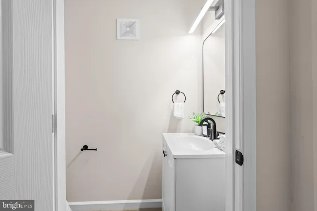 a bathroom with a sink and mirror with window