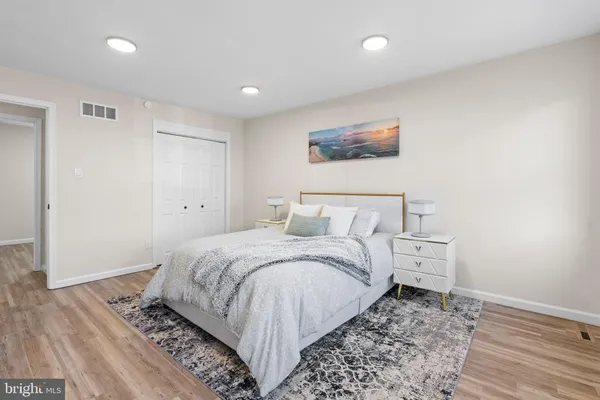 a spacious bedroom with a bed and a wooden floor