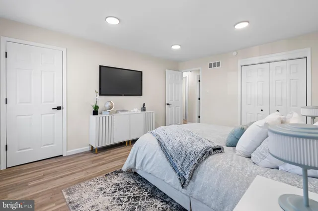 a spacious bedroom with a bed and a flat screen tv