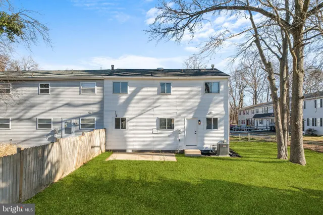 a front view of house with yard and trees in the background