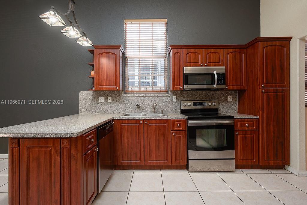 3436 Southwest 152nd Pass Miami, FL 33185 - Photo 4 of 36 a kitchen with stainless steel appliances granite countertop a refrigerator and a stove top oven