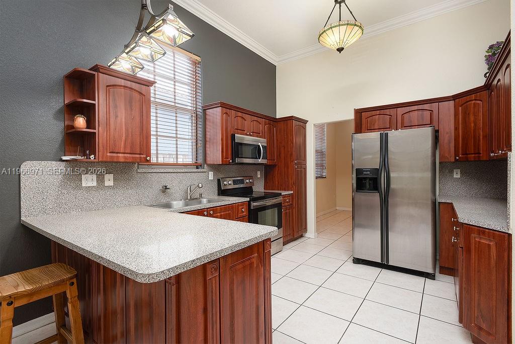 3436 Southwest 152nd Pass Miami, FL 33185 - Photo 7 of 36 a kitchen with a refrigerator a microwave a sink and a stove