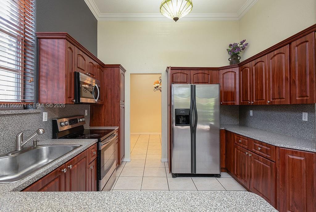 3436 Southwest 152nd Pass Miami, FL 33185 - Photo 8 of 36 a kitchen with stainless steel appliances granite countertop a refrigerator a sink dishwasher a stove with wooden cabinets and floor