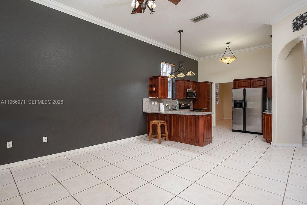 3436 Southwest 152nd Pass Miami, FL 33185 - Photo 10 of 36 a kitchen with stainless steel appliances kitchen island granite countertop a refrigerator and a stove top oven