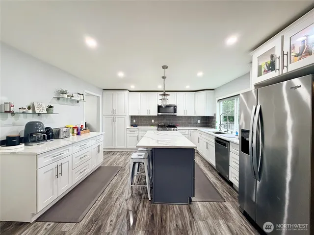 a kitchen with stainless steel appliances a sink stove and refrigerator