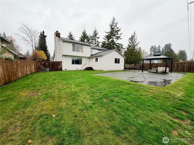 a view of a house with a big yard and large trees