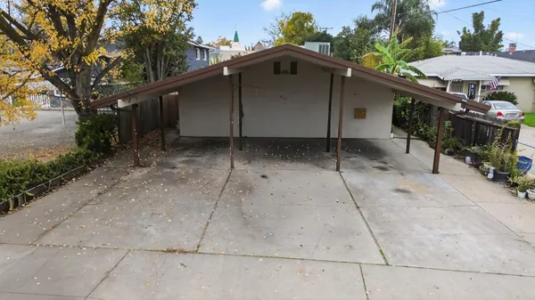 a small barn with a table and chairs under an umbrella