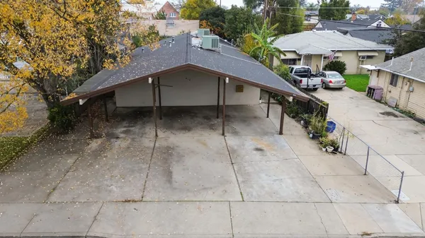 a backyard of a house with table and chairs under an umbrella