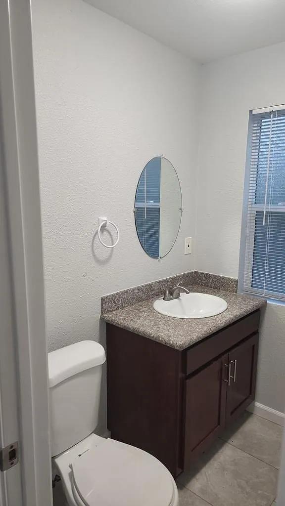 834 South Washington Street Lodi, CA 95240 - Photo 8 of 42 a bathroom with a granite countertop toilet sink and mirror