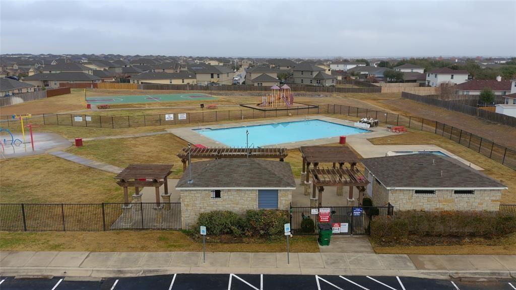 14917 Gypsum Mill Road Manor, TX 78653 - Photo 15 of 28 A vibrant community hub featuring a spacious pool, playground, and sports court for active living.