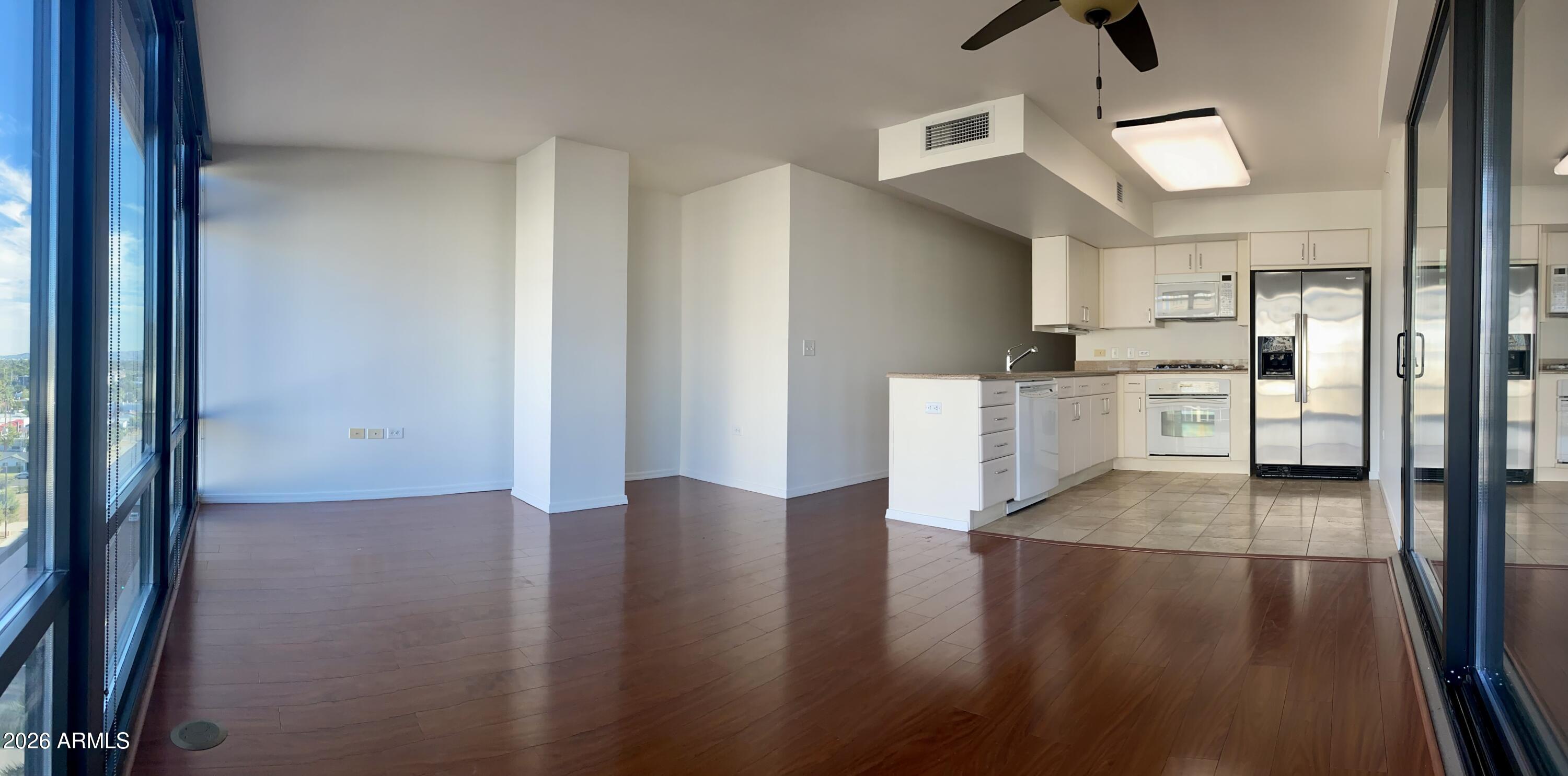 4808 North 24th Street, Unit 1102 Phoenix, AZ 85016 - Photo 3 of 20 a view of a kitchen with wooden floor and a refrigerator