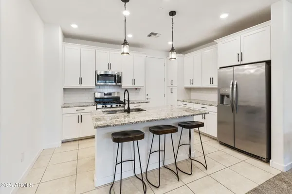 a kitchen with stainless steel appliances granite countertop a stove a refrigerator and a refrigerator