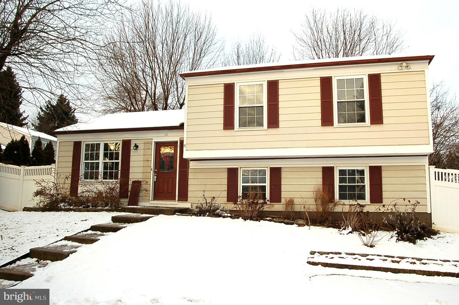 a front view of a house with a yard covered in snow