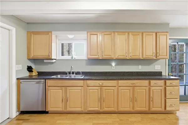 a kitchen with granite countertop white cabinets and sink