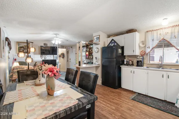 a kitchen with stainless steel appliances granite countertop a refrigerator dining table and chairs