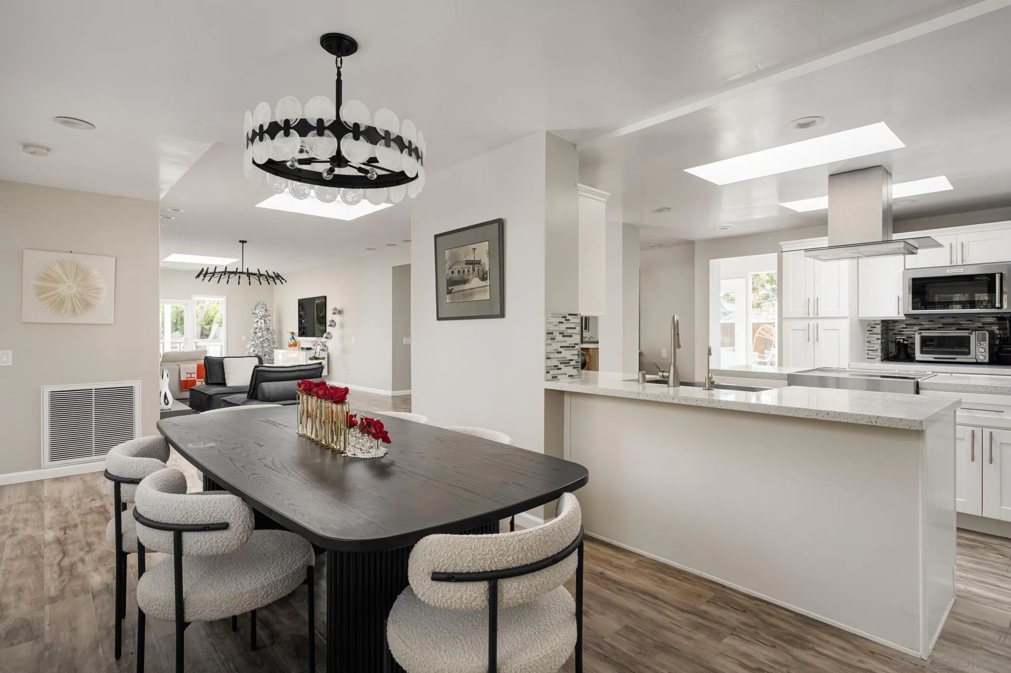 7026 Estrella De Mar Road Carlsbad, CA 92009 - Photo 11 of 46 a view of a dining room with furniture a chandelier and wooden floor