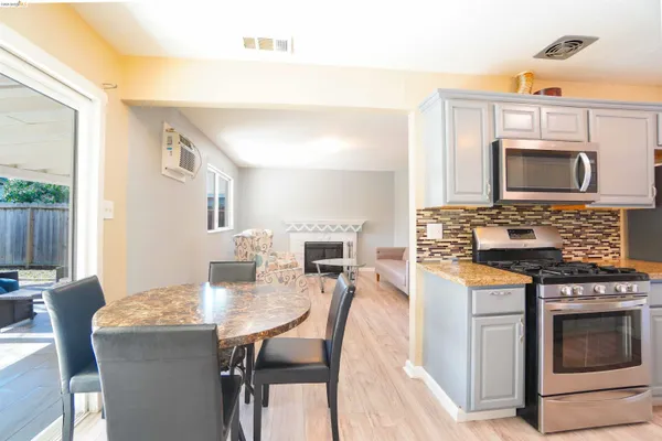 a kitchen with a stove a microwave a dining table and chairs