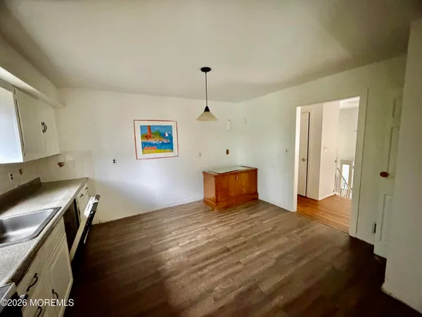 a kitchen with granite countertop a refrigerator and a stove top oven