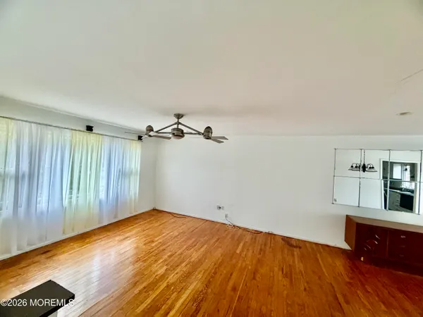 a view of an empty room with wooden floor