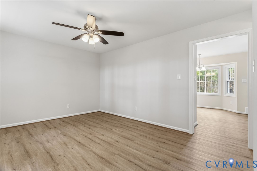 14624 Wilkinson Road Dewitt, VA 23840 - Photo 5 of 47 an empty room with wooden floor chandelier and windows