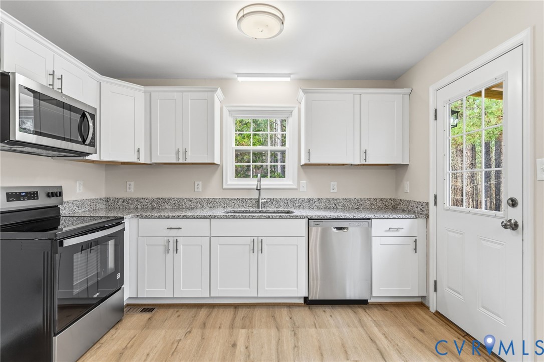 14624 Wilkinson Road Dewitt, VA 23840 - Photo 7 of 47 a kitchen with stainless steel appliances granite countertop a stove a sink and a microwave