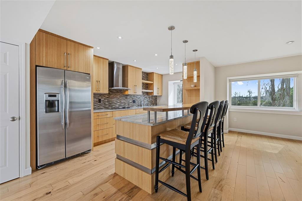 6206 Masters Boulevard, Unit 302 Orlando, FL 32819 - Photo 4 of 32 a kitchen with stainless steel appliances kitchen island granite countertop a table chairs and a refrigerator