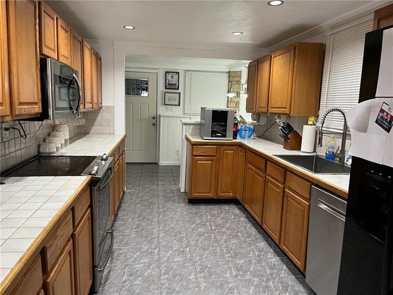 205 Stone Church Road Grindstone, PA 15442 - Photo 21 of 25 a kitchen with stainless steel appliances granite countertop sink stove top oven and cabinets