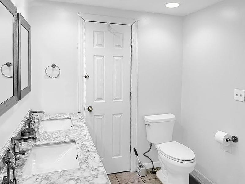 205 Stone Church Road Grindstone, PA 15442 - Photo 5 of 25 a bathroom with a granite countertop toilet a sink and a mirror