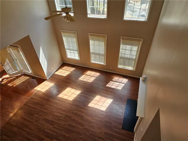 an empty room with wooden floor and windows