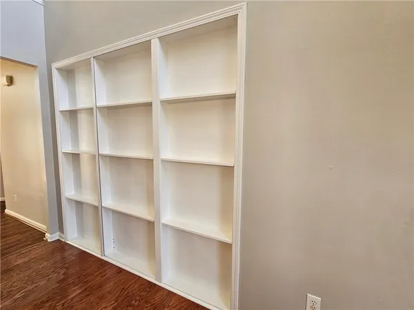 an empty room with wooden floor and fireplace